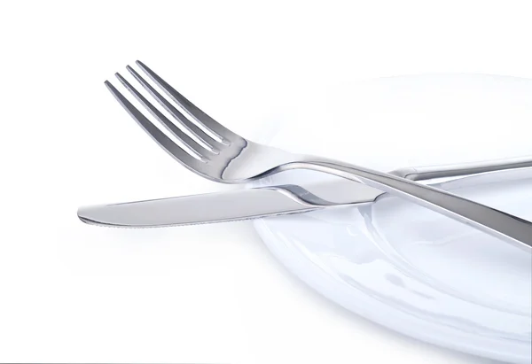 Close up of a silver knife and fork on plate isolated — Stock Photo, Image