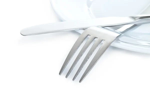 Nahaufnahme eines silbernen Messers und einer Gabel auf einem Teller isoliert — Stockfoto