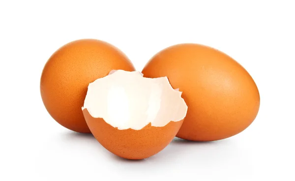 Two brown eggs on a white background. One egg is broken — Stock Photo, Image