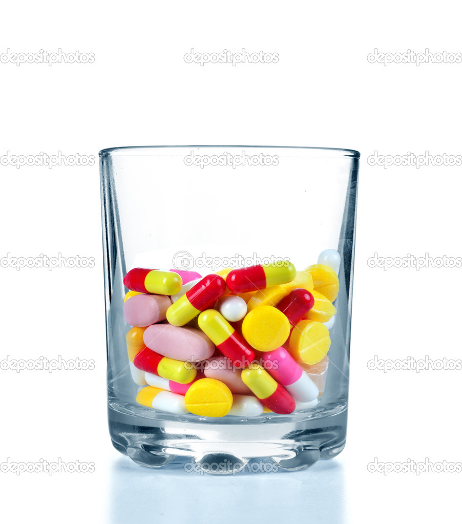 Many colorful drugs and pills in glass on white background