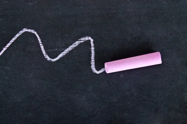 Close-up of pink piece of chalk on blackboard — Stock Photo, Image