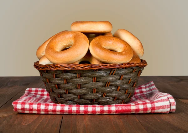 Sabrosos bagels en cesta sobre fondo de madera Fotos de stock libres de derechos