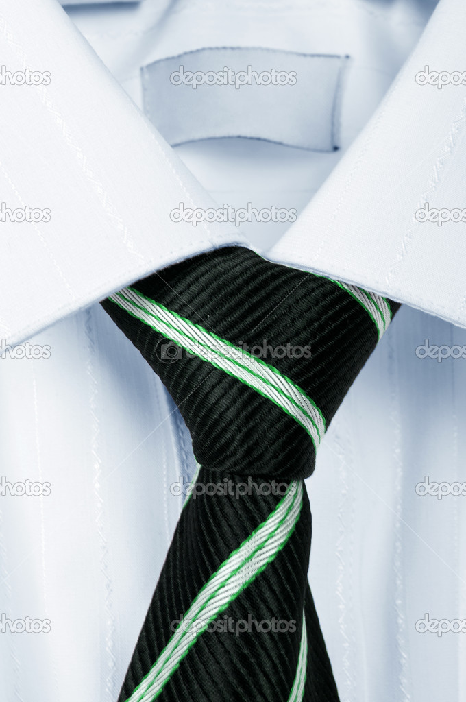 White shirt with a tie on a wooden hanger