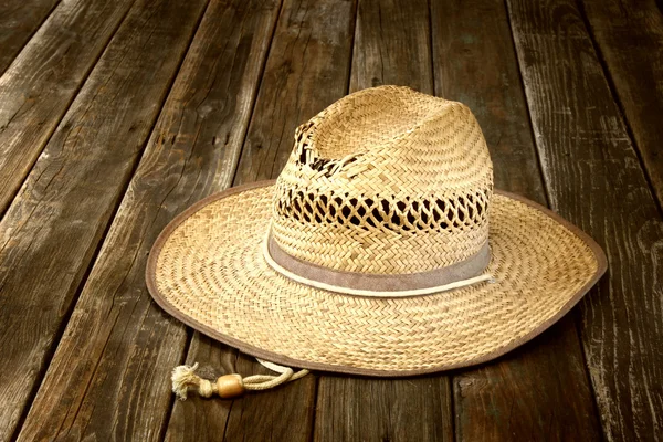 Плетеная шляпа на деревянном столе — стоковое фото