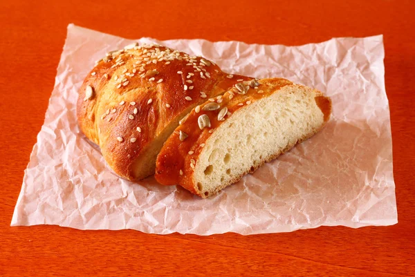 Zelfgebakken brood in bakken papier op houten tafel, selectieve aandacht — Stockfoto