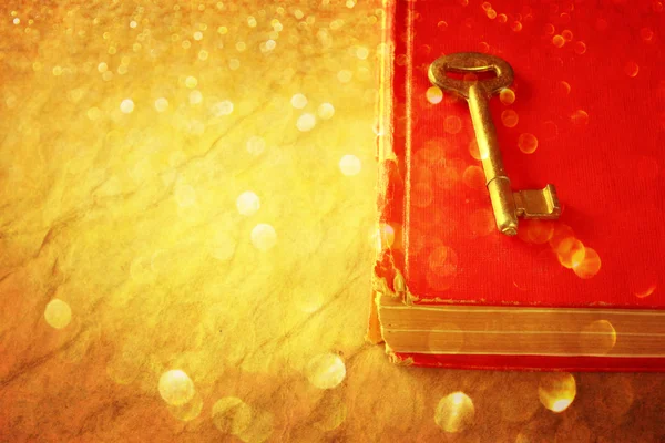Red book and vintage key and golden glitter lights — Stock Photo, Image