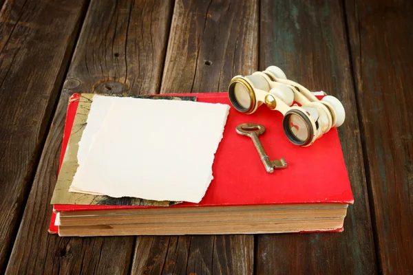 Vintage binoculars on red ancient book with blank page for text. nostalgic vintage background — Stock Photo, Image