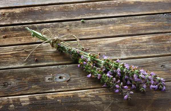 Květy šalvěje a rozmarýnu na dřevěný stůl — Stock fotografie