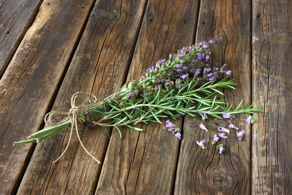 Květy šalvěje a rozmarýnu na dřevěný stůl — Stock fotografie