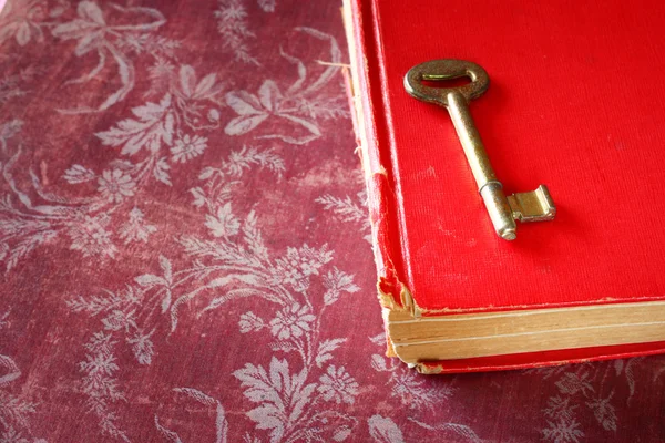 Libro vintage rojo con llave clásica dorada en la cubierta —  Fotos de Stock