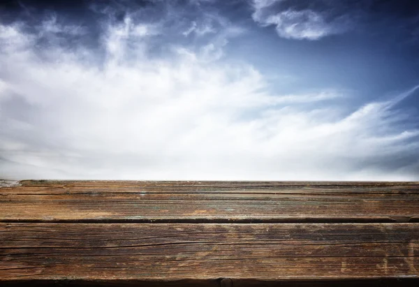 Wooden deck table over sky background — Stock Photo, Image