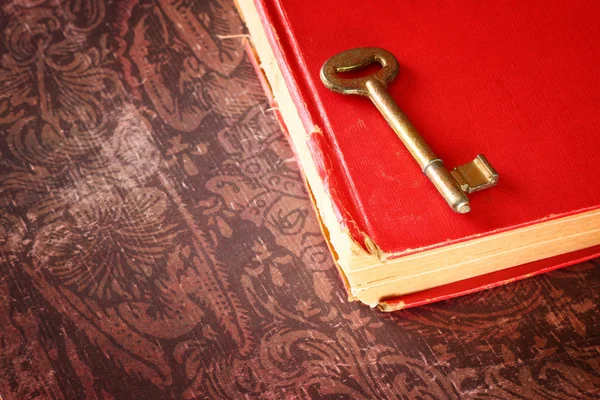 Red vintage book with golden classic key on cover