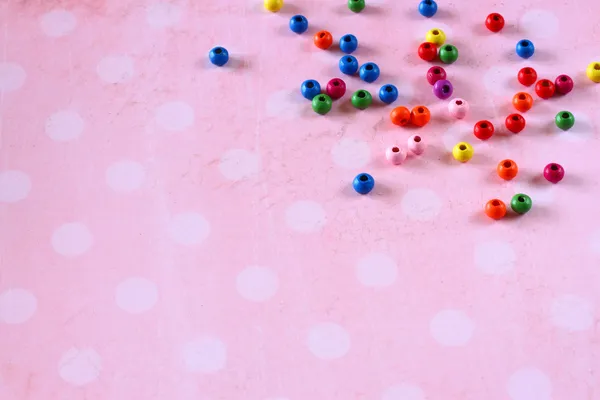 Perles colorées sur fond vintage rose à pois — Photo