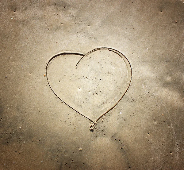 Corazón dibujando en la arena en la playa — Foto de Stock