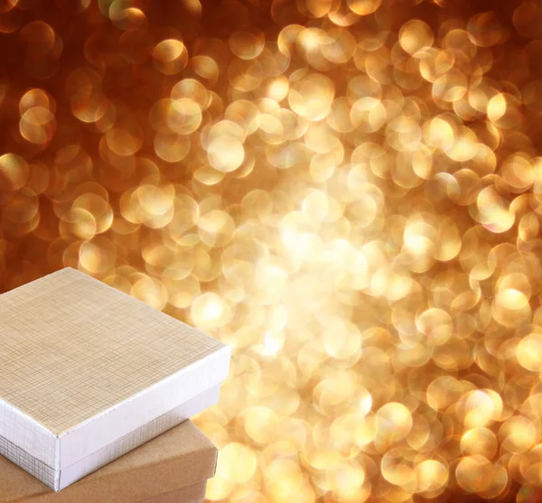 Weihnachtsgeschenkbox auf dem Hintergrund defokussierter goldener Lichter. — Stockfoto