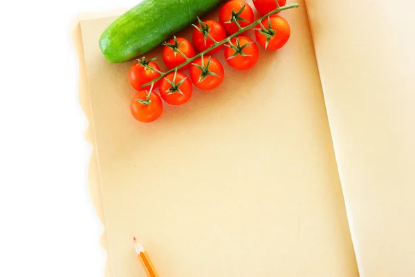 木製の背景とノートの紙の上に新鮮な野菜. — ストック写真