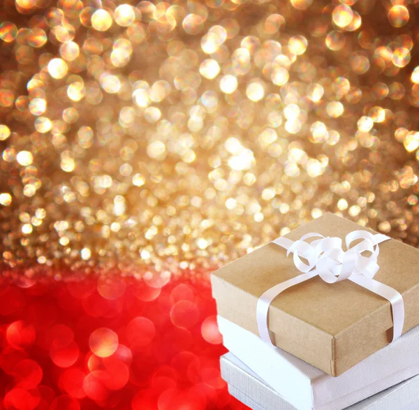 Christmas Gift over red and golden lights background — Stock Photo, Image