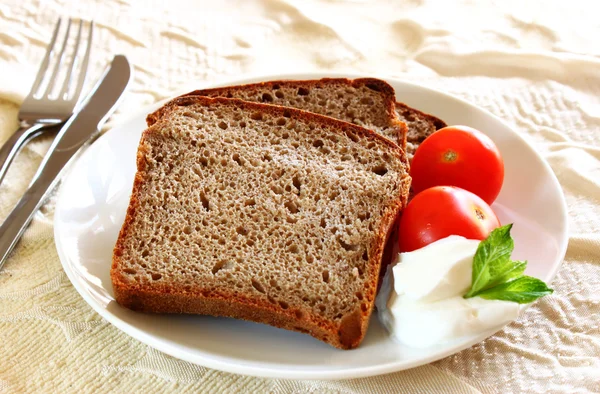 Sliced bread with spread cheese and cherry tomato on white plate — Stock Photo, Image