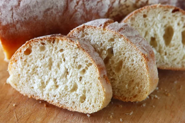 Delicioso pão fatiado na mesa de madeira — Fotografia de Stock