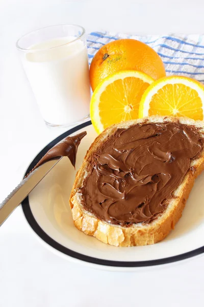 Chocolate cream on a slice of bread and knife — Stock Photo, Image
