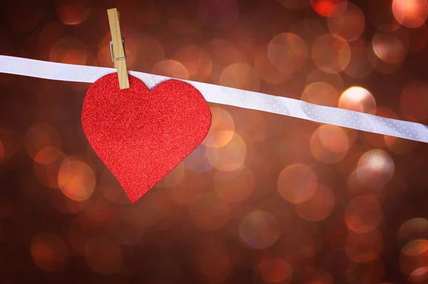 Red glitter heart hang over brown bokeh background — Stok Foto