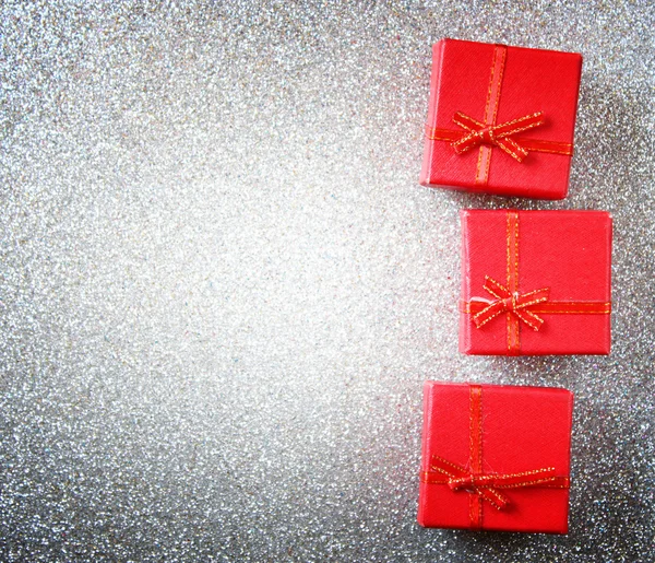 Cajas de regalo rojas sobre fondo de plata brillante — Foto de Stock