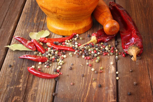 Mortero y mortero con pimientos rojos y hoja de laurel — Foto de Stock