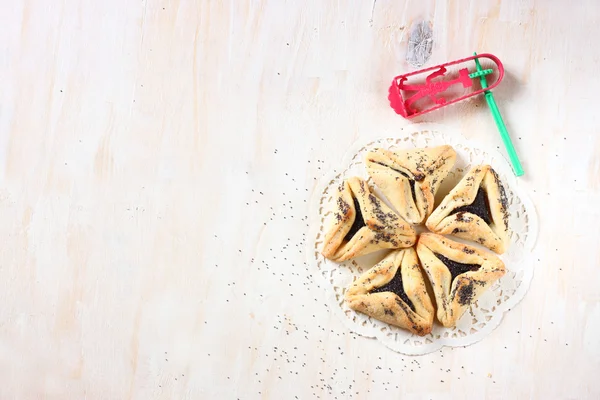 Hamantaschen biscuits ou hamans oreilles pour la célébration de Pourim et bruyant sur panneau en bois texturé — Photo