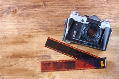 eski vintage fotoğraf makinesi ve fotoğraf ahşap kahverengi zemin üzerinde Üstten Görünüm.