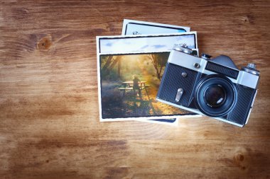 eski vintage fotoğraf makinesi ve fotoğraf ahşap kahverengi zemin üzerinde Üstten Görünüm.