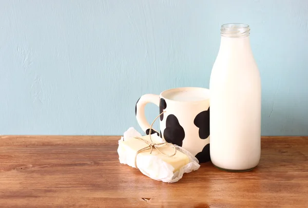 Mjölk och cup på träbord — Stockfoto