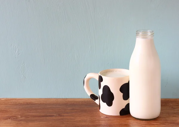 Milch und Tasse auf Holztisch — Stockfoto