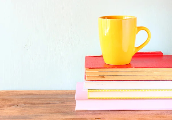 Gul kopp kaffe på gamla vintage böcker — Stockfoto