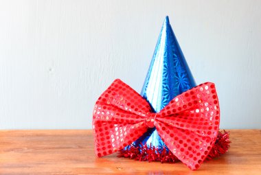 블루 광대 모자와 나무 테이블 위에 큰 나비 넥타이niebieski kapelusz i duża muszka nad drewnianym stołem