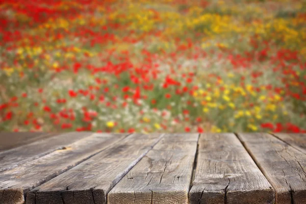 Table en bois avec champ de fleurs — Photo