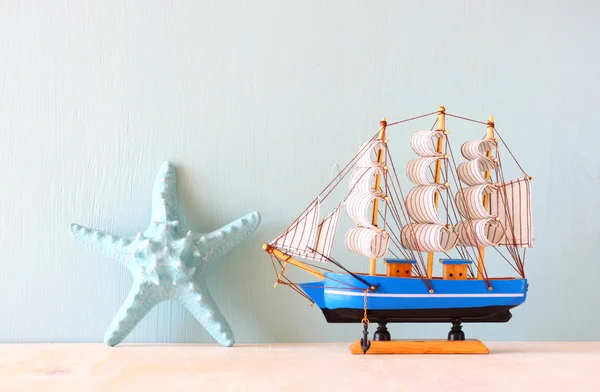 Modelo de brinquedo de navio de madeira e estrela do mar — Fotografia de Stock