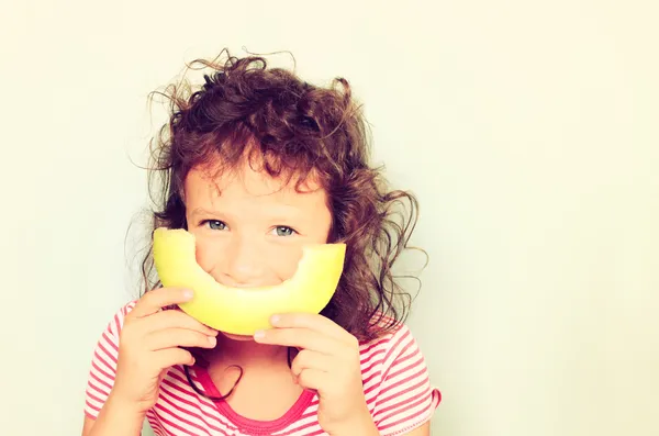 Un mignon gosse qui mange du melon. image filtrée . — Photo