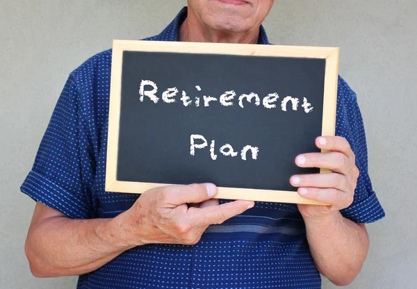 Uomo anziano in possesso di lavagna con la frase piano pensionistico scritto su di esso — Foto Stock