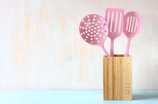 Kitchen utensils over wooden textured background — Stock Photo, Image