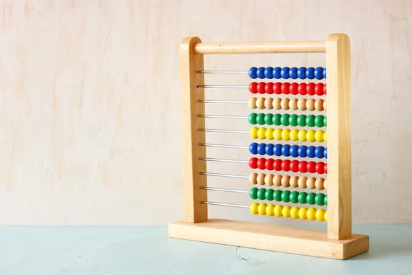 Abacus con cuentas sobre fondo texturizado de madera — Foto de Stock