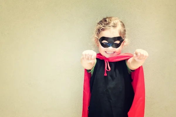 Superheld kind tegen getextureerde muur achtergrond. spelen activiteit concept — Stockfoto