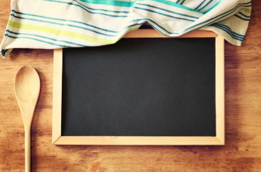 yazı tahtası ve ahşap masa üzerine tahta kaşıkla üstten görünüm. Filtre uygulanmış görüntü