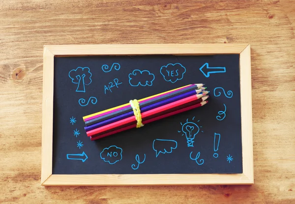 Top view of pencils stack over blackboard and various drawing — Stock Photo, Image