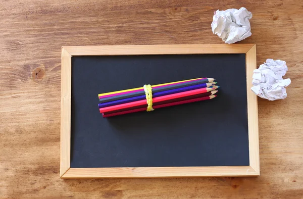 Top view of blackboard , stack of pencils and crumpled paper. — Stock Photo, Image