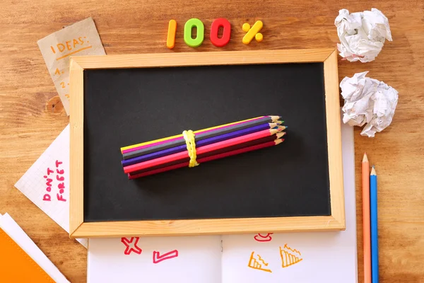 Top view of blackboard , stack of pencils and crumpled paper. — Stock Photo, Image