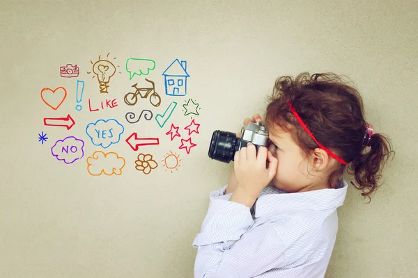 Conceito de garoto bonito olhando através do visor da câmera vintage e vários desenhos — Fotografia de Stock