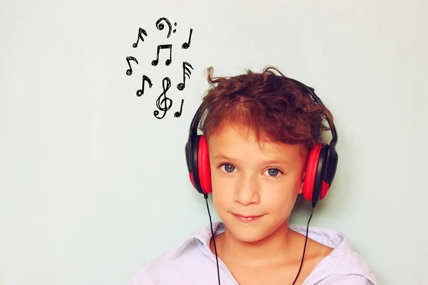 Cute kid  (girl) with headphones having fun listening to music,  and notes sketches. — Stock Photo, Image