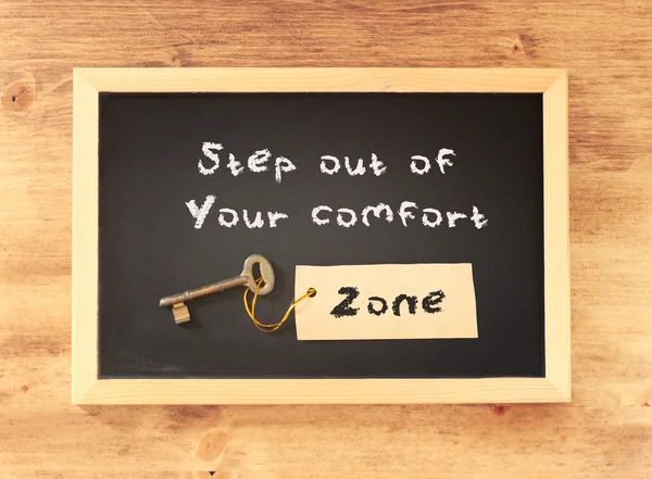 De woordgroep stap uit je comfortzone geschreven op blackboard — Stockfoto