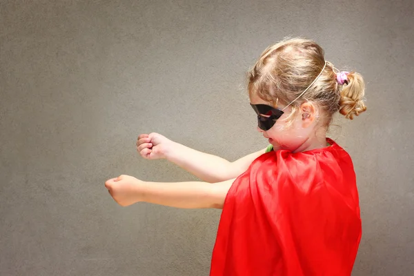 Criança super-herói contra parede texturizada — Fotografia de Stock