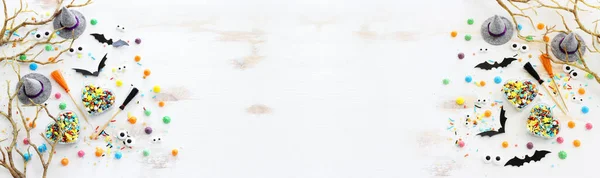 ハロウィーンの最高の景色の画像 魔女の帽子 ほうき 裸の木 白い木製のテーブルの上の御馳走とコウモリ — ストック写真